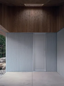 Modern minimalist entrance with corrugated metal materials and concrete floor.