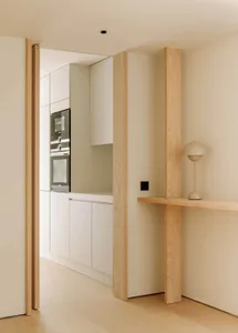 Modern, minimalist kitchen with white cabinetry and sleek appliances.