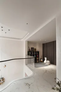 A modern, minimalist entrance hallway with marble flooring, white walls, and a glass railing. Features include a white rabbit