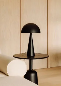 Modern minimalist living room featuring a sleek, black, metal table lamp with a wooden top.