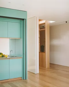 Modern kitchen featuring sleek, minimalist design with lacquered wood cabinets and a glass countertop.