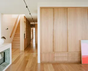 A modern, minimalist residential interior featuring wooden elements and clean lines, with a focus on simplicity and functiona