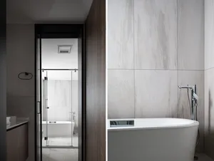 Modern minimalist bathroom featuring spacious marble walls and a white bathtub with chrome fixtures.