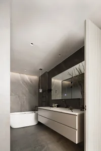 Photo of a modern bathroom interior with marble finishes, a freestanding bathtub, and a floating vanity.