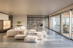 Modern minimalist living room with concrete flooring and furniture.