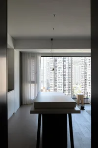 Modern apartment kitchen with granite countertops and black wooden legs overlooking a cityscape through floor-to-ceiling wind