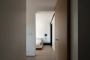 A modern minimalist bedroom featuring neutral tones and a sleek design.