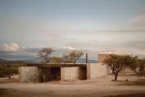 A modern residential building with a stone exterior and minimalist design.