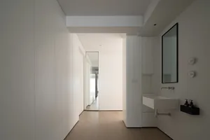 A minimalist bathroom with white materials and a modern, clean design.