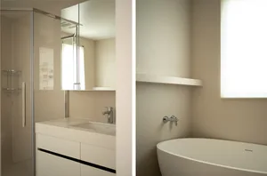 Minimalist bathroom with white ceramic sink, glass shower, and metal faucet.