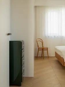 Minimalist bedroom with wooden furniture and a bed.