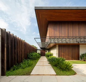 Modern house exterior featuring wooden panels and concrete elements.