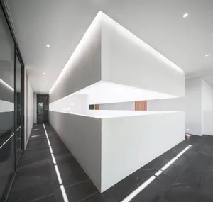A minimalist office interior featuring concrete walls and flooring.