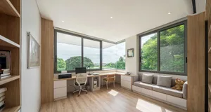 Modern home office with a desk, chairs, and a built-in couch.