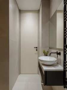 Modern minimalist bathroom with concrete walls and floor, white sink, and black accents.