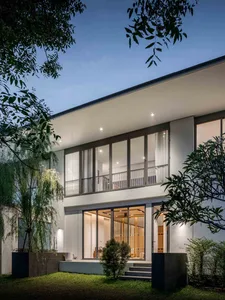 A modern residential exterior featuring glass, aluminum, and steel materials.