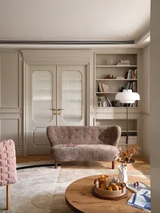 Circular rug with a modern minimalist living room setup, featuring a plush sofa, bookshelves, and a round wooden coffee table