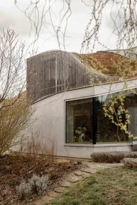 Modern house with concrete facade and large windows.
