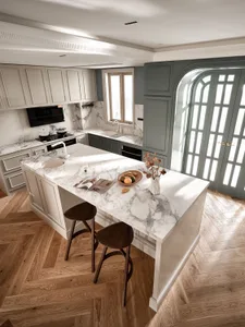 Modern kitchen featuring a marble countertop with wooden stools and a decorative vase.