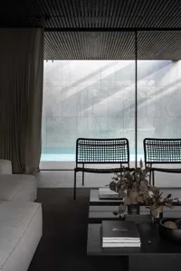 Modern living room with minimalist design featuring concrete furniture and walls.