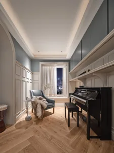 A modern living room with a wooden floor, featuring a comfortable armchair, a piano, and a serene atmosphere.