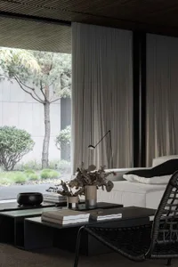 A minimalist living room featuring a white textured sofa adorned with cushions.