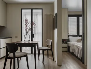 Modern minimalist living space with a wooden table, chairs, and vase with flowers.