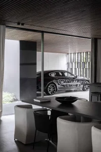 Modern minimalist residential interior with concrete, glass, and metal materials.
