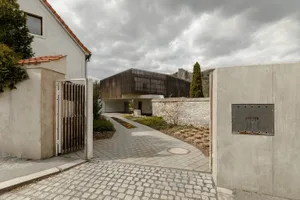 A contemporary exterior residential building with concrete, wood, and metal materials.