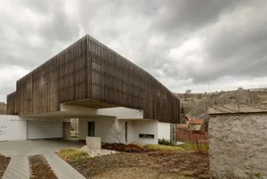 Modern residential building with wooden facade and industrial-style features.