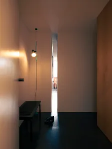 An entryway with minimalist design featuring a concrete floor and a lamp.