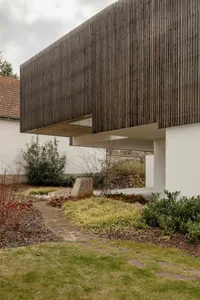 The minimalist exterior of a modern house features a wooden paneled wall.