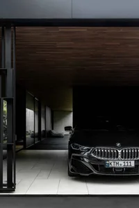 A sleek, modern automotive carport featuring a black sedan as the centerpiece, showcasing a minimalist architectural design.