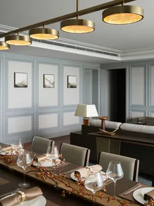 A modern dining room featuring metallic light fixtures and sleek furniture.