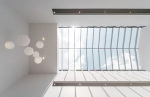 Modern interior design featuring a glass ceiling with a white structure and minimal lighting.