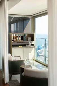 A modern living room with glass walls and a view of the city.