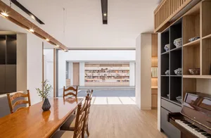 A modern living room and library space featuring wooden and glass materials.