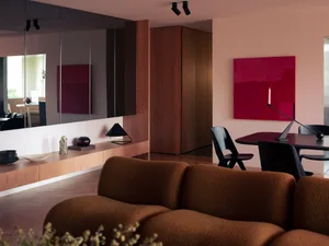 Modern living room with plush brown couch, wooden cabinets, and a red abstract painting on the wall.