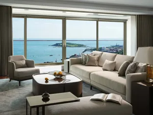 Modern luxury living room featuring neutral-toned furniture and a stunning ocean view.