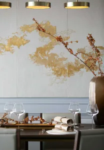 Modern restaurant dining area featuring metallic pendant lights and decorative branches in a vase.