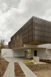 Modern residential building with wood facade and large windows.