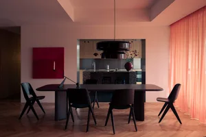Contemporary dining room featuring black furniture, wooden floors, and a red art piece.