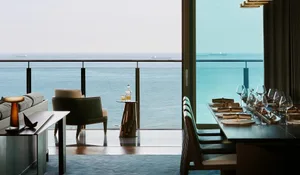 Modern dining room with glass windows overlooking the sea.