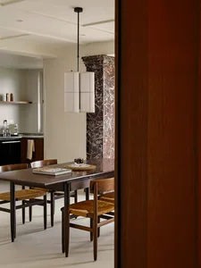 Minimalist dining room featuring wooden furniture and a marble column.