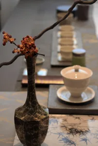 A minimalist interior design featuring ceramic vases and cups, with wooden branches adding a natural touch.