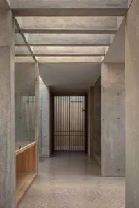 A minimalist interior design showcasing a concrete floor, glass walls, and wooden accents.