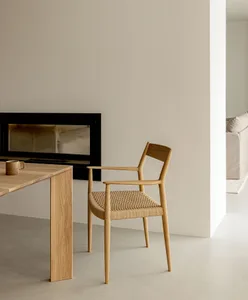 A minimalist residential dining room featuring wooden furniture.