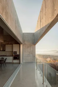 An exterior view of a modern building with concrete walls and a clear sky in the background.