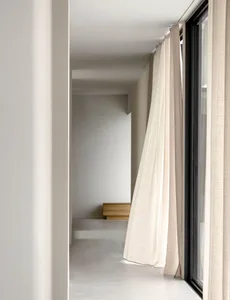 Lighting design in a modern room with minimalistic decor and fabric curtains.