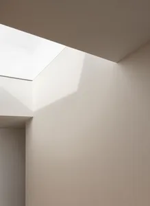 Minimalist interior design featuring natural light through a large window.